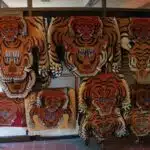 Tiger rugs, faces eyes, teeth, claws, handmade wool carpets and rugs hanging on a display rack, abstract, Boudha, Kathmandu, Nepal