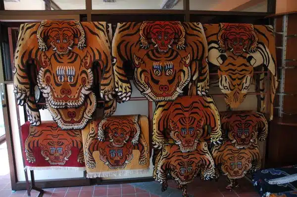 Tiger rugs, faces eyes, teeth, claws, handmade wool carpets and rugs hanging on a display rack, abstract, Boudha, Kathmandu, Nepal