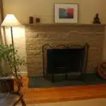 Zen style - painted stone fireplace makeover with flat black slate inlayed hearth, pillows, Buddha candleholder, original art, rocking chair, Ikea curtains, Seattle, Washington, USA