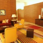 Lounge room, sofas, pillows, armchairs, end tables, lamps, art, sideboard, wood walls, striped carpet, red and yellow, contemporary furniture, Renaisance Hotel, Schaumburg, Illinois, USA