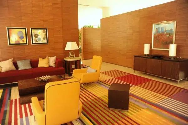 Lounge room, sofas, pillows, armchairs, end tables, lamps, art, sideboard, wood walls, striped carpet, red and yellow, contemporary furniture, Renaisance Hotel, Schaumburg, Illinois, USA