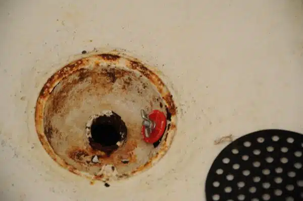 View of the broken stinky sewer drain with a red plug, cover, shower, Broadview duplex, Seattle, Washington, USA