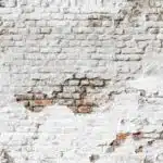 Damaged white brick wall