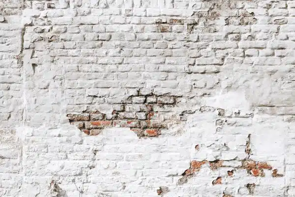 Damaged white brick wall